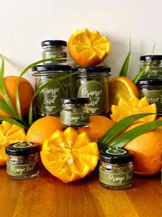 Bocal de fleur de CBD Orange Bud posé parmi des oranges coupées